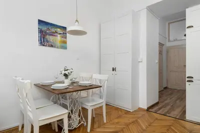 a kitchen and dining room with a table and chairs at Atmospheric Apartment Close to the Vistula Boulevards by Noclegi Renters in Kraków