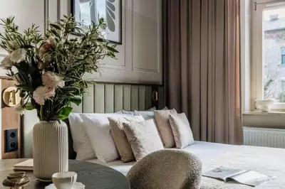 a living room with a couch and a vase with flowers at The Garden Collection in Kraków