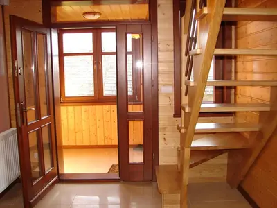 a wooden staircase in a room with a window at Agroturystyka Śliwkowy Sad in Biesiadki
