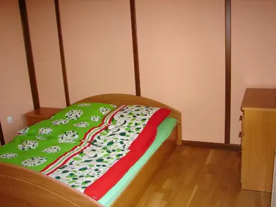 a bed with a green and red blanket on it at Agroturystyka Śliwkowy Sad in Biesiadki