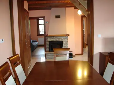 a dining room with a table and a fireplace at Agroturystyka Śliwkowy Sad in Biesiadki