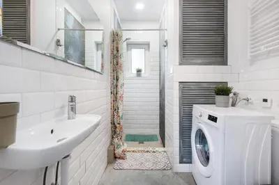 a white bathroom with a sink and a washing machine at MAWKA near Enerdgylandia in Zator
