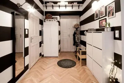 a hallway with black and white striped walls and a refrigerator at MAGICAL apartment in Kraków