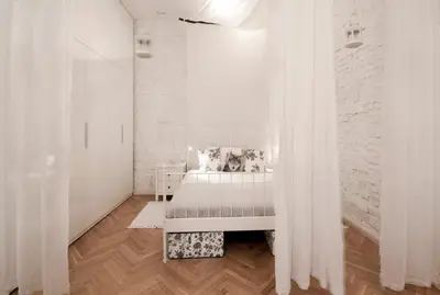 a white bedroom with a bed and white curtains at MAGICAL apartment in Kraków