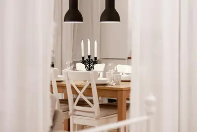 a dining room with a table with white chairs and candles at MAGICAL apartment in Kraków