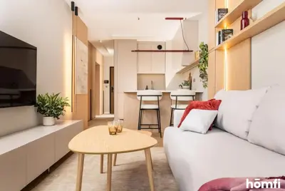 a living room with a white couch and a table at Winewood Apartment - homfi Collection in Kraków