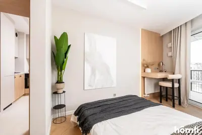 a bedroom with a bed and a plant on the wall at Winewood Apartment - homfi Collection in Kraków