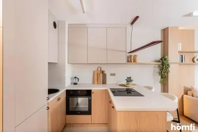 a kitchen with white cabinets and a stove top oven at Winewood Apartment - homfi Collection in Kraków