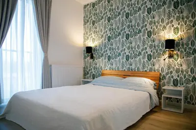 a bedroom with a bed with a patterned wall at Krzemień Apartment in Oświęcim