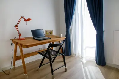 a desk with a laptop on it with a chair at Krzemień Apartment in Oświęcim