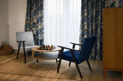 a living room with a table and a chair and a chessboard at Krzemień Apartment in Oświęcim