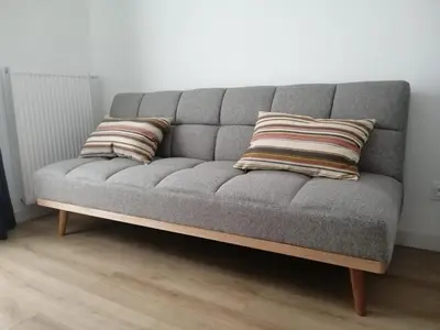 a gray couch with two pillows on top of it at Krzemień Apartment in Oświęcim