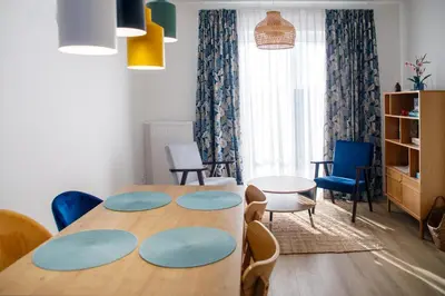 a dining room with a table and chairs and a room at Krzemień Apartment in Oświęcim
