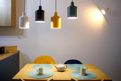 a dining room table with plates and cups and lights at Krzemień Apartment in Oświęcim