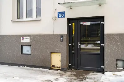 a door to a building with snow in front of it at Bonarka Homely Studio by BookingHost in Kraków