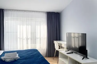 a bedroom with a bed and a desk with a television at Halicka 5 Superior Studio by BookingHost in Kraków