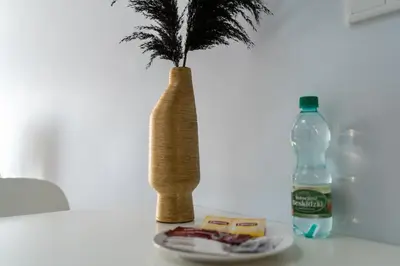 a vase with a plant and a bottle of water at Halicka 5 Superior Studio by BookingHost in Kraków