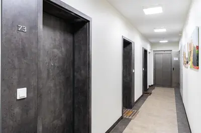 a corridor of elevators in a office building with black doors at Halicka 5 Superior Studio by BookingHost in Kraków