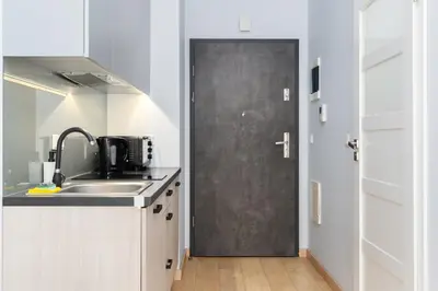 a kitchen with a black door next to a sink at Halicka 5 Superior Studio by BookingHost in Kraków