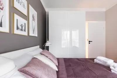 a bedroom with a bed with pink and white pillows at Pink Boutique Apartment 60m2 & Garage in Kraków