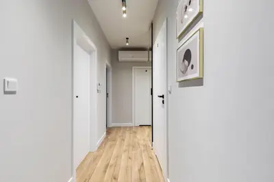 an empty hallway with white walls and wood floors at Pink Boutique Apartment 60m2 & Garage in Kraków