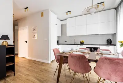 a kitchen and dining room with a table and chairs at Pink Boutique Apartment 60m2 & Garage in Kraków