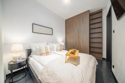 a bedroom with a bed with a nightstand and a table at Kościuszki Apartment N1 - AirCon - by Rentujemy in Kraków