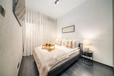 a bedroom with a bed with a table on it at Kościuszki Apartment N1 - AirCon - by Rentujemy in Kraków