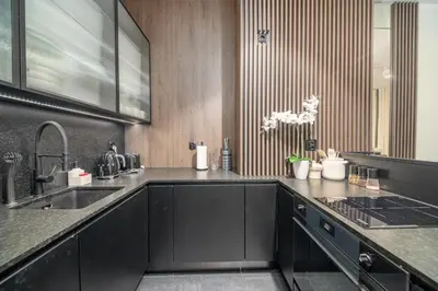 a kitchen with black cabinets and a sink at Kościuszki Apartment N1 - AirCon - by Rentujemy in Kraków