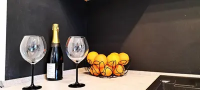a bottle of champagne and two wine glasses on a counter at Quiet Apartment in Oświęcim