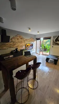 a living room with a wooden table and stools at Odpoczynek w Parku, Free Parking!! in Kraków