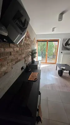 a kitchen with a black counter and a brick wall at Odpoczynek w Parku, Free Parking!! in Kraków
