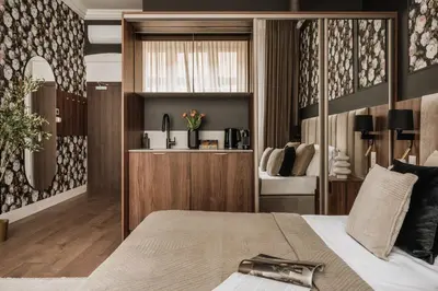 a bedroom with a bed and a vanity with a mirror at White Lotus by Fragola Apartments in Kraków