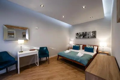 a bedroom with a bed and a table and chairs at Carmel Apartment by Cracovia Prime in Kraków