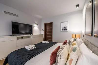 a bedroom with a large bed with a flat screen tv at Carmel Apartment by Cracovia Prime in Kraków