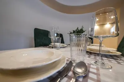 a table with a plate and glasses on a table at Carmel Apartment by Cracovia Prime in Kraków