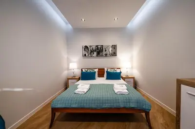 a bedroom with a bed with blue pillows at Carmel Apartment by Cracovia Prime in Kraków