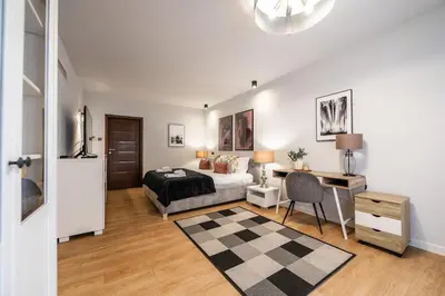 a bedroom with a bed and a desk and a bed sidx sidx sidx at Carmel Apartment by Cracovia Prime in Kraków