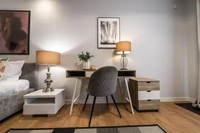 a bedroom with a desk with a chair and a bed at Carmel Apartment by Cracovia Prime in Kraków