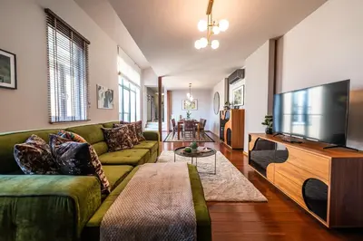 a living room with a green couch and a flat screen tv at Boho13 Apartment by Cracovia Prime in Kraków