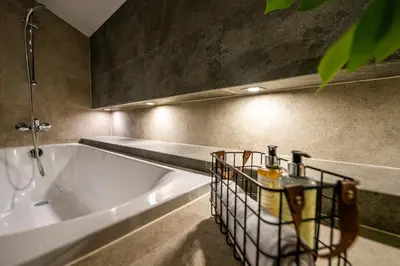 a bathroom with a large tub and a sink at Boho13 Apartment by Cracovia Prime in Kraków