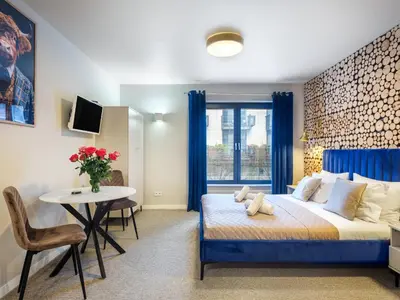 a bedroom with a bed and a table and a window at Boho and Forest Studios by Tyzenhauz in Kraków