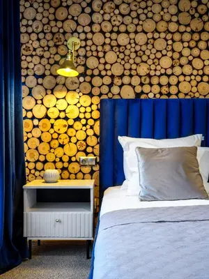 a bedroom with a bed and a wall of logs at Boho and Forest Studios by Tyzenhauz in Kraków