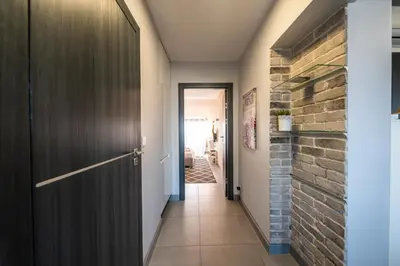 a hallway with a door and a brick wall at Meadows9 Apartment by Cracovia Prime in Kraków