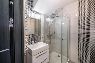 a white bathroom with a sink and a shower at Meadows9 Apartment by Cracovia Prime in Kraków
