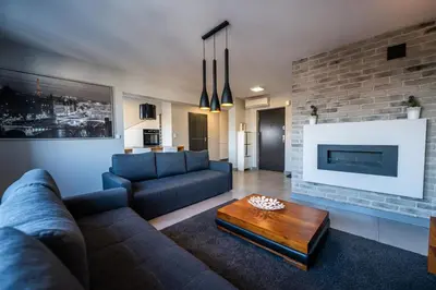 a living room with a couch and a fireplace at Meadows9 Apartment by Cracovia Prime in Kraków