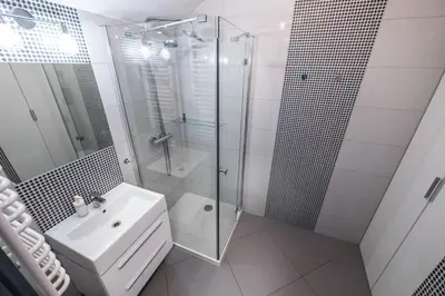 a bathroom with a glass shower and a sink at Meadows9 Apartment by Cracovia Prime in Kraków