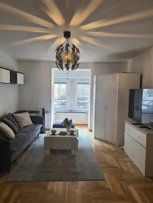 a living room with a couch and a chandelier at Chill Apartment with Jacuzzi in Kraków