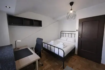 a bedroom with a bed and a desk and a table at Chill Apartment with Jacuzzi in Kraków