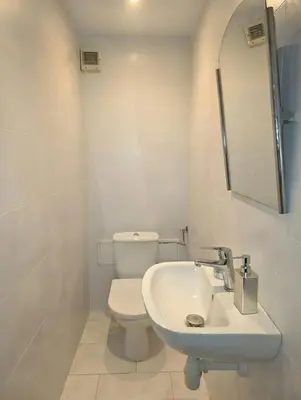 a white bathroom with a toilet and a sink at Chill Apartment with Jacuzzi in Kraków